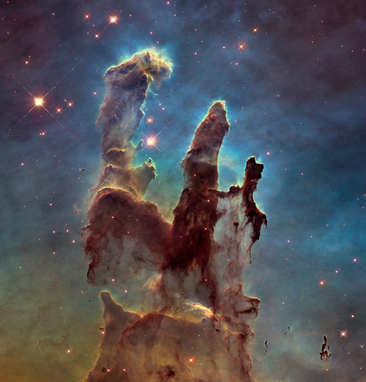 Yksi tähtitieteen ikonisimmista kuva-aiheista ovat Kotkasumun “Luomisen pilarit”. Tämä kuva on otettu Hubble-avaruusteleskoopin 25-vuotisjuhlavuonna paremmalla kameralla, kun alkuperäinen Hubblen kuva vuodelta 1995 oli jo ennättänyt esiintyä elokuvissa, tv-sarjoissa, t-paidoissa, tyynyissä ja jopa postimerkissä. Pilarit osoittavat erehtymättä kohti noin neljää hyvin massiivista tähteä, jotka syntyivät sumussa ensimmäisten joukossa reilut miljoona vuotta sitten. Niistä massiivisin vastaa noin 80 Aurinkoa. Pilareista vasemmanpuolimmaisin on hiukan tähtiä kauempana siten, että sen meille päin näkyvä kylki näkyy selvästi valaistuna. Kaksi muuta pilaria on hiukan meitä lähempänä, ja ne näyttävät meille varjoiset selkäpuolensa. Myös Auringon uskotaan muodostuneen Kotkasumun tapaisessa ympäristössä. Aurinkokunnasta on löytynyt radioaktiivisia alkuaineita, joita uskotaan syntyvän vain massiivisten tähtien räjähtäessä supernovina. Aurinkokunnan kehittyessä lähistöllä on siis ollut vasta muodostunut, nopeasti kehittynyt massiivinen tähti – samanlainen kuin ne, jotka ovat säteilyllään muovanneet Luomisen pilarit. Kuva NASA, ESA / Hubble and the Hubble Heritage Team