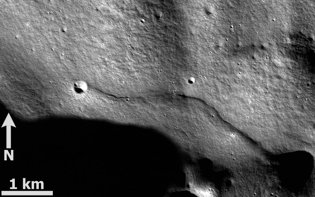 Kuva 5. Lobate scarp -tyyppinen ylityöntösiirros Kuun etäpuolella, pohjoisnavan lähellä sijaitsevan Rozhdestvenskiy-kraatterin reunalla. Lobate scarp -rakenteilla toinen reuna on tyypillisesti hyvin loiva, mutta toisen reunan muodostaa jyrkänne. Ne myös yleensä hieman mutkittelevat kuvan rakenteen tapaan. Kuvassa alaosan kalliolohko on työntynyt yläosan lohkon päälle. Kuva (Mercator-projektio): ASU / LRO NAC M105505727LE.IMG / T. Öhman.
